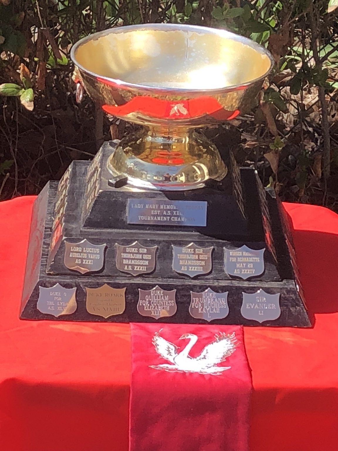A large trophy on a small table with a red talecloth
